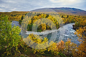 Sunny fall autumn view of Abisko National Park, Kiruna Municipality, Lapland, Norrbotten County, Sweden, with Abiskojokk river, photo