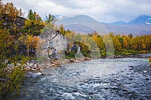 Sunny fall autumn view of Abisko National Park, Kiruna Municipality, Lapland, Norrbotten County, Sweden, with Abiskojokk river, photo