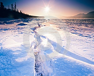 Sunny frozen Tagish Lake ice crack Yukon Canada