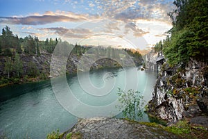 Sunny landscape of orange sunrise, forest and bright blue mountain river