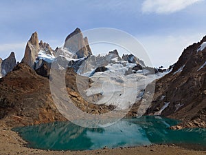 Sunny Mountains with Turquoise Lake. Snow Lying on the Slope of the Mountain.