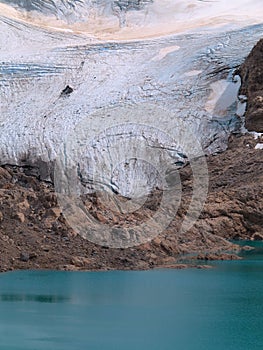 Sunny Mountainside Covered by Snow. Turquoise Lake.