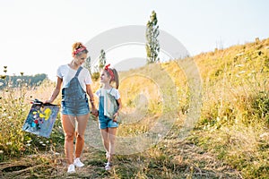 Sunny nature, mom and daughter paint a picture in a park , painting a Little Child, Child Creativity. Mother& x27;s Day.
