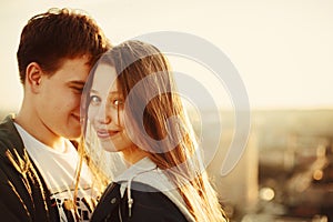 Sunny outdoor portrait of young happy couple