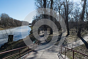 Sunny park with melting river during spring time