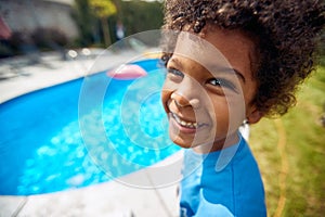 Sunny Poolside Bliss: Afro-American Boy\'s Infectious Laughter by the Water