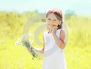 Sunny portrait of cute smiling little girl child with flowers