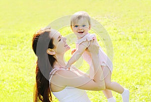 Sunny portrait happy mother and baby having fun in summer