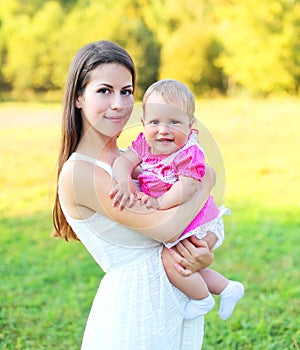 Sunny portrait happy smiling mother and baby together in summer