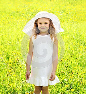 Sunny portrait of little girl child outdoors on the meadow