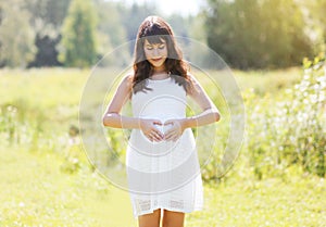 Sunny pretty pregnant woman outdoors
