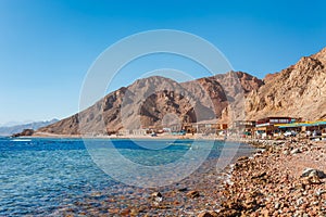 Sunny resort beach at the coast shore of Red Sea in Dahab, Sinai, Egypt, Asia in summer hot. Famous tourist destination Blue Hole