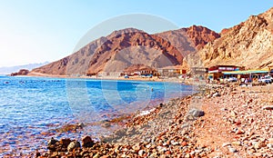 Sunny resort beach at the coast shore of Red Sea in Dahab, Sinai, Egypt, Asia in summer hot. Famous tourist destination Blue Hole