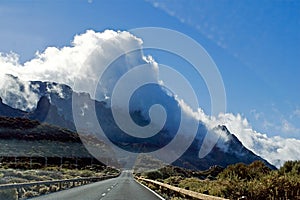 Sunny road between the gorges on the track to the Teide volcano, between the clouds movement, blurry, Tenerife, natural background