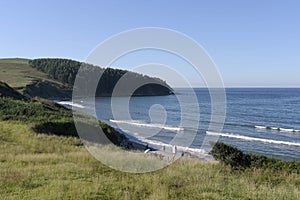 Sunny scenery of a sandy beach of Oyambre natural park in San Vicente de la Barquera, Spain