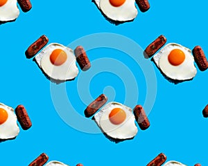 Sunny side up eggs. Fried eggs and sausages pattern on blue background