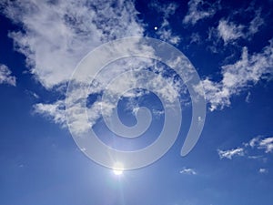 Sunny sky background. Blue sky with clouds, sun shining and moon.