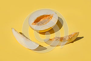 Sunny sliced melon with seeds on yellow background