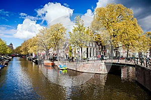 Sunny spring day in Amsterdam. Canal view with boats and bicycles, Netherlands