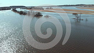 On a sunny spring day, the camera flies fast and low over a flooded field.