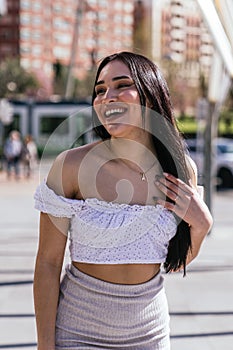 Sunny Street Style: Beautiful Latina Smiling in Modern Casual Attire with Tram in Background photo
