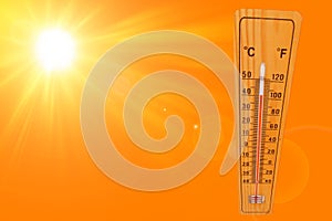 Sunny summer background with the thermometer marking a temperature over 40 degrees and bright sun on an orange background