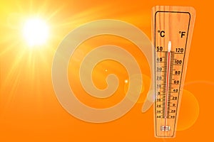 Sunny summer background with the thermometer marking a temperature over 50 degrees and bright sun on an orange background