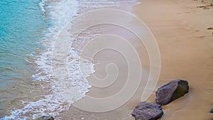 Sunny summer beach ocean waves with bubbles and sand background