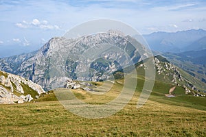 WALLPAPER sunny summer day in the mointains Green fields in front of a great mountain peak  Massive rocks with blue sky and clouds photo
