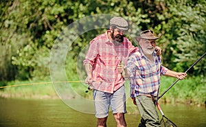 Sunny summer day at river. Fisherman family. Hobby sport. Fishing peaceful activity. Father and son fishing. Rod tackle