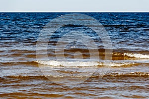 sunny summer scene of Baltic sea with beautiful seaside with waves.