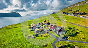 Sunny summer view from flying droneof Kirkjubour village with Hestur Island on background. Fantastic morning scene of Faroe Island