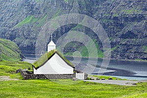 Sunny summer view of traditional turf-top church Saksunar Kirkja