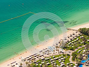 Sunny vacation in Dubai. Beach with tourists. View from a height.