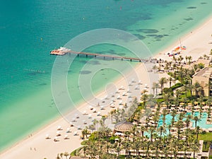 Sunny vacation in Dubai. Beach with tourists. View from a height.