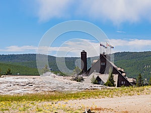 Sunny view of the Old Faithful geyser and Old Faithful Inn