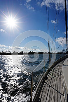 Sunny view from a sailboat on the coast where windmills stand for green energy.