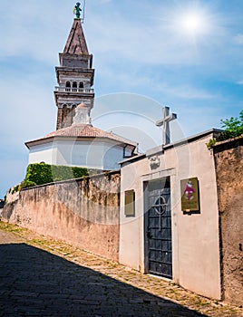 Sunny view of St. George`s Parish Church in old town Piran. Colorful spring morning Slovenia, Europe. Traveling concept backgroun