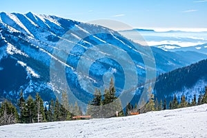 Sunny Weather Over Empty Ski Slope and Mountain Peaks