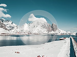 Sunny winter day in Reine, fishing village in Norway, drone shot on amazing landscape in Lofoten. Lovely clouds and blue sky