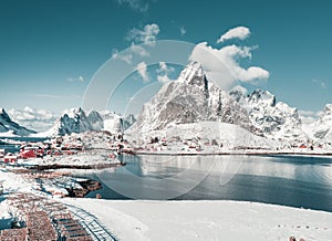 Sunny winter day in Reine, fishing village in Norway, drone shot on amazing landscape in Lofoten. Lovely clouds and blue sky