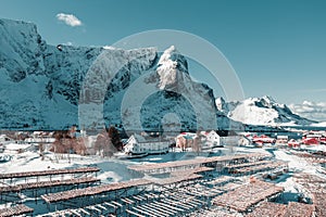 Sunny winter day in Reine, fishing village in Norway, drone shot on amazing landscape in Lofoten. Lovely clouds and blue sky.