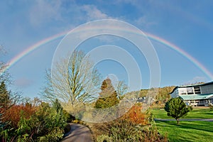 On a sunny winter day, RHS Garden, Harrogate, England, is stunningly highlighted by a rainbow.