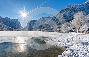 A sunny winter morning at a snowy and iced Lake Dobbiaco, Province of Bolzano, Trentino Alto Adige, Italy.