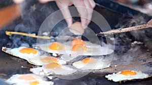 Sunnyside up eggs cooking on a barbecue hot plate