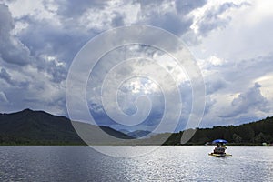 Sunrays breaking through storm clouds over mountain lake