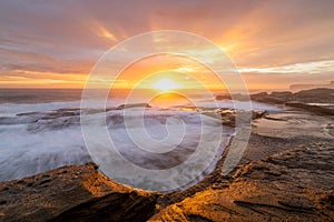 Rayos de sol desgarrando más amanecer el sol sobre el hermoso línea costera 