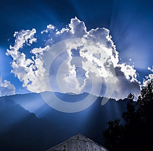 Sunrays penetrate through clouds in the beautiful blue sky photo
