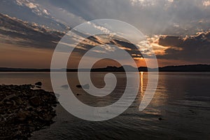 Sunrays after sunset in San Ignacio, Misiones, Argentina, with little mountains in the horizon and the river shore at the left