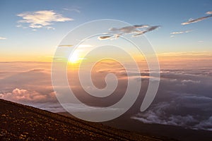 Sunrise above clouds and warm sky.